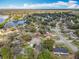 A landscape aerial view showing a pond, neighborhood, and tree canopy in a sunny area at 302 Log Run Ct, Ocoee, FL 34761