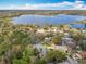 Scenic aerial view showcases lakefront homes surrounded by lush greenery under a bright blue sky at 302 Log Run Ct, Ocoee, FL 34761