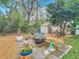 Landscaped backyard featuring a fire pit, quaint shed, and an array of potted plants at 302 Log Run Ct, Ocoee, FL 34761