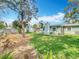 Green backyard with a well-maintained lawn, a charming sunroom, and a shed in the distance at 302 Log Run Ct, Ocoee, FL 34761