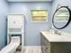 Bathroom with blue walls features a decorative mirror, cabinet above the toilet and modern vanity sink at 302 Log Run Ct, Ocoee, FL 34761