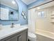 Bathroom with blue walls, large mirror, new vanity, white tile and bath tub at 302 Log Run Ct, Ocoee, FL 34761