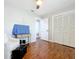 Neutral bedroom with hardwood floors, ceiling fan, white chair, ottoman and closet at 302 Log Run Ct, Ocoee, FL 34761