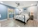 Bedroom features a queen bed, hardwood floors, ceiling fan, textured wall and large window at 302 Log Run Ct, Ocoee, FL 34761