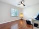 Neutral bedroom with hardwood floors, ceiling fan, large window, soft chair and ottoman at 302 Log Run Ct, Ocoee, FL 34761