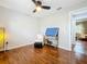 Neutral bedroom with hardwood floors, ceiling fan, lamp, soft chair and ottoman at 302 Log Run Ct, Ocoee, FL 34761