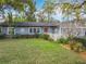 Charming home with vibrant landscaping, a red front door, and classic details at 302 Log Run Ct, Ocoee, FL 34761