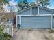 Attached two-car garage, complete with exterior lighting and neutral siding at 302 Log Run Ct, Ocoee, FL 34761