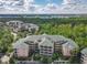 Panoramic view of the Caribe Cove condos showcasing lush greenery, parking, and a distant lake at 3050 Pirates Retreat Ct # 207, Kissimmee, FL 34747