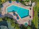 Overhead view of the pool and jacuzzi with many lounge chairs, tables, and palm trees at 3050 Pirates Retreat Ct # 207, Kissimmee, FL 34747