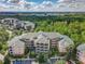 Wide aerial shot of Caribe Cove condos featuring lush greenery, parking, and distant lake views at 3050 Pirates Retreat Ct # 207, Kissimmee, FL 34747