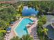 Community pool and spa with lounge chairs and tables situated next to a serene lake at 3050 Pirates Retreat Ct # 207, Kissimmee, FL 34747