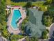 Aerial view of a community pool and clubhouse next to each other surrounded by greenery at 3050 Pirates Retreat Ct # 207, Kissimmee, FL 34747