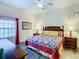 Cozy bedroom with wood-look flooring features a ceiling fan and natural light from the window at 3050 Pirates Retreat Ct # 207, Kissimmee, FL 34747