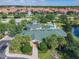 Aerial view of the meticulously maintained clubhouse, lush landscaping, and inviting pool at 3050 Pirates Retreat Ct # 207, Kissimmee, FL 34747