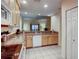 Open floor plan view of kitchen area featuring wooden cabinets, white appliances, and granite countertops at 3050 Pirates Retreat Ct # 207, Kissimmee, FL 34747