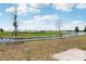 View of neighborhood pond surrounded by young landscaping and paver path at 3189 Viceroy Ct, Poinciana, FL 34759
