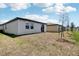 View of backyard showing new construction with slider and budding lawn at 3189 Viceroy Ct, Poinciana, FL 34759