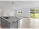 Modern kitchen island featuring a stainless steel sink and granite countertops at 3190 Viceroy Ct, Poinciana, FL 34759