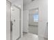 Bathroom features a clear glass shower and neutral tile flooring at 3559 Broadwing Blvd, Poinciana, FL 34759