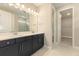 Bathroom featuring double vanity with dark blue cabinets and marble-style tile flooring at 360 Birkdale Dr, Daytona Beach, FL 32124