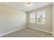 Bedroom with two sunny windows showing neighborhood view and neutral carpet at 360 Birkdale Dr, Daytona Beach, FL 32124