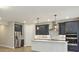 Modern kitchen featuring stainless steel appliances, a center island, and elegant dark blue cabinetry at 360 Birkdale Dr, Daytona Beach, FL 32124