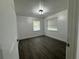 Cozy bedroom with hardwood floors and natural light from two bright windows at 4005 Clarcona Ocoee Rd, Orlando, FL 32810