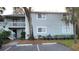 The exterior of a two-story condo shows mature landscaping and dedicated parking spots at 4164 Plantation Village Condos Dr # 504, Orlando, FL 32810