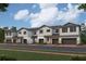 Modern townhome exteriors featuring two-story design, attached garages, white accents, and landscaped surroundings at 4307 Campsite Loop, Orlando, FL 32824