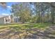 Lush backyard featuring a well-maintained lawn, mature trees, and a screened pool area at 4532 Saddleworth Cir, Orlando, FL 32826