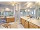 Bright bathroom with dual sinks, wood cabinets, and large mirrors at 4532 Saddleworth Cir, Orlando, FL 32826