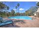 Community swimming pool featuring a brick paver deck, palm trees, and lounge seating at 4532 Saddleworth Cir, Orlando, FL 32826