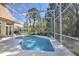 Relax in this sparkling screened pool surrounded by a lush backyard and a covered patio at 4532 Saddleworth Cir, Orlando, FL 32826