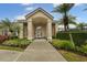 Front exterior of community clubhouse with covered entryway, featuring well-manicured landscaping at 4865 Cypress Woods Dr # 2105, Orlando, FL 32811