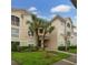 Well-maintained condo building with a blend of tan and green exterior, complemented by lush, landscaped grounds at 4865 Cypress Woods Dr # 2105, Orlando, FL 32811