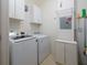 This laundry room has a washer, dryer, storage cabinets and shelving at 4865 Cypress Woods Dr # 2105, Orlando, FL 32811