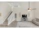 Bright living room with a high ceiling, a ceiling fan, staircase, and a television at 5021 Sweet Leaf Ct, Altamonte Springs, FL 32714