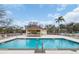 Sparkling community pool with seating area, mature landscaping and clear blue sky at 5021 Sweet Leaf Ct, Altamonte Springs, FL 32714