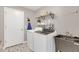 Bright laundry room with patterned tile flooring, washer, dryer, shelving, and wash basin at 5021 Sweet Leaf Ct, Altamonte Springs, FL 32714