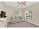 Cozy living room with neutral carpet, a ceiling fan, and a bright window offering natural light at 5021 Sweet Leaf Ct, Altamonte Springs, FL 32714