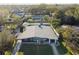 Aerial view of a single-story home featuring mature landscaping and a long driveway at 5073 Lake Howell Rd, Winter Park, FL 32792