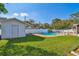 Landscaped backyard featuring a pool and a storage shed at 5073 Lake Howell Rd, Winter Park, FL 32792