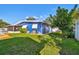 Bright backyard with a blue house, green lawn, and white picket fence at 5073 Lake Howell Rd, Winter Park, FL 32792