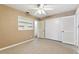 Bedroom features a ceiling fan, a closet, neutral carpet, and a built-in shelf at 5073 Lake Howell Rd, Winter Park, FL 32792