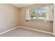 Neutral bedroom with beige walls, gray carpeting, and a window with light curtains at 5073 Lake Howell Rd, Winter Park, FL 32792