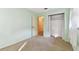 Bright bedroom with neutral carpet, an open closet, and light green walls at 5073 Lake Howell Rd, Winter Park, FL 32792