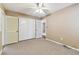 Neutral bedroom features a ceiling fan, double closets, and neutral carpet at 5073 Lake Howell Rd, Winter Park, FL 32792