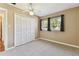 This bedroom features neutral carpeting, two windows with curtains, and a ceiling fan at 5073 Lake Howell Rd, Winter Park, FL 32792