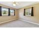 Bedroom with two windows, neutral carpet and paint, plus dark curtains at 5073 Lake Howell Rd, Winter Park, FL 32792